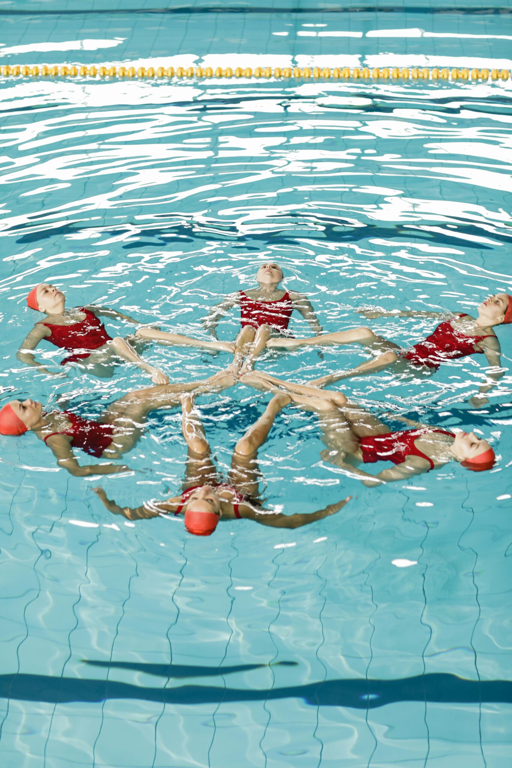 Ladies in a pool performing synchronized swimming, inspiring marketing lessons.