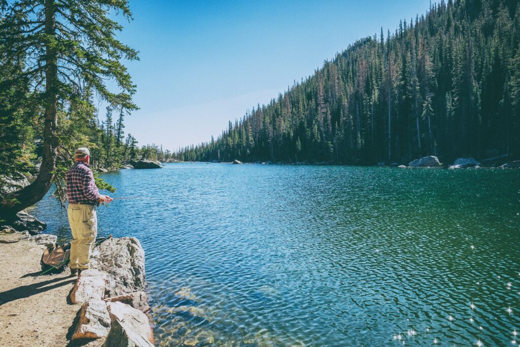 Man standing next to a lake fishing. It's like he's fishing for a marketing strategy.