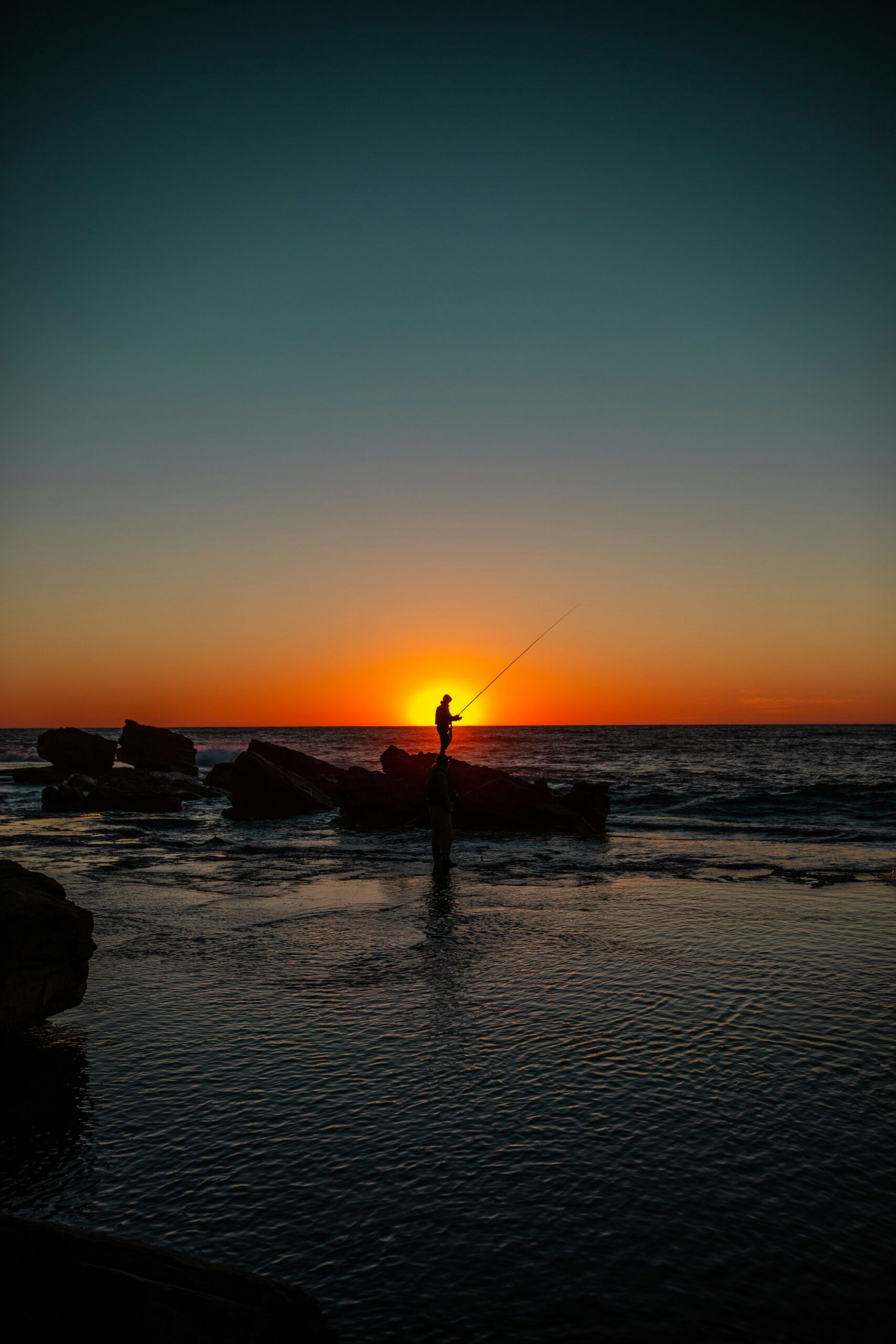 Fishing in the ocean at sunset